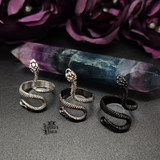 Snake Ring in three different colors sitting in front of a fluorite pointed crystal.
